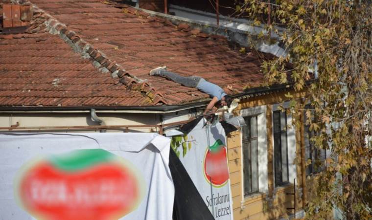 O anlar kameraya yansıdı… Çatıdan sarkıp afiş astı